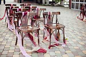 Wedding chairs with tapes,wedding ceremony in outside.rustik style. White door arch in green tree background.