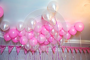 Wedding or children birthday party decoration interior . Helium balloons . Pink and white balloons float on the white ceiling in