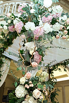 Wedding chuppah decorated with fresh flowers indoor banquet hall of wedding ceremony. Luxury wedding florist decoration artwork