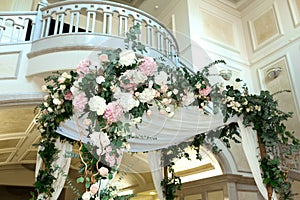 Wedding chuppah decorated with fresh flowers indoor banquet hall of wedding ceremony. Luxury wedding florist decoration artwork