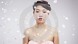 Wedding, confetti and serious asian woman in studio on gray background for marriage event. Portrait, party and bored
