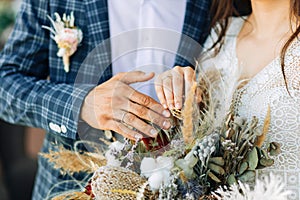 Wedding couple , beautiful bride and groom in the studio, wedding bouquet, bride and groom hold each other`s hands. Wedding rings