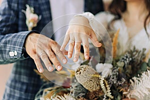 Wedding couple , beautiful bride and groom in the studio, wedding bouquet, bride and groom hold each other`s hands. Wedding rings