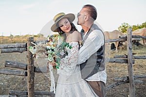 Wedding couple in the boho style on the ranch. Designer wedding bouquet.