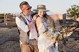Wedding couple in the boho style on the ranch. Designer wedding bouquet.
