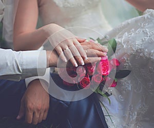 Wedding couple, bride and groom, hands with rings and pink gentle bouquet flowers closeup, country, rustic style