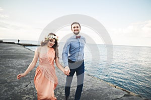 Wedding couple, bride, groom walking and posing on pier