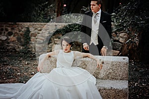 Wedding couple. The bride is sitting. The groom stands
