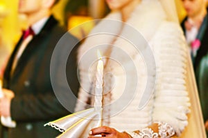 Wedding couple in church with candle in hands