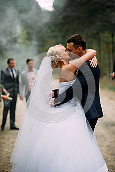 Wedding couple with color smoke in the summer park.