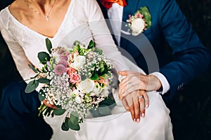 Wedding couple with detail on wedding bouquet and rings