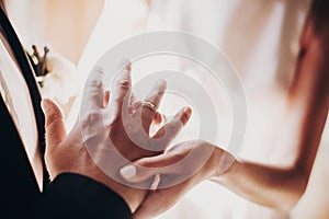 Wedding couple exchanging wedding rings during holy matrimony in church. Bride and groom putting golden rings on finger, close up photo