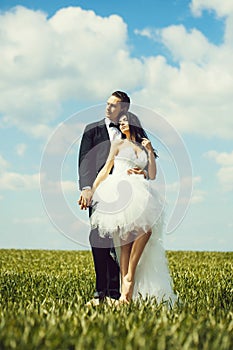 Wedding couple on green grass and blue sky