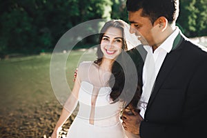 Wedding couple, groom and bride hugging, outdoor near river