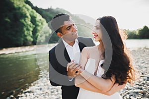 Wedding couple, groom and bride hugging, outdoor near river