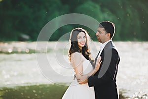 Wedding couple, groom and bride hugging, outdoor near river