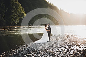 Wedding couple, groom and bride hugging, outdoor near river