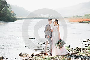 Wedding couple, groom and bride hugging, outdoor near river