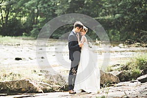 Wedding couple, groom and bride hugging, outdoor near river