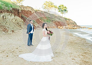 Wedding couple, groom and bride in wedding dress near the sea at the seaside