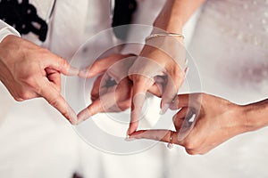Wedding couple hands and heartshaped fingers photo