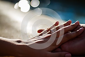 Wedding couple holding hands on bokeh background