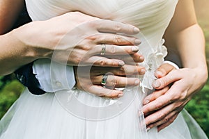 Wedding couple hugging outdoors. Bride and groom holding hands together. Love concept. Elegant clothes