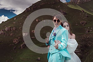 wedding couple hugs and looks at the camera, cheerful groom jokes. photography in the mountains in summer, close-up