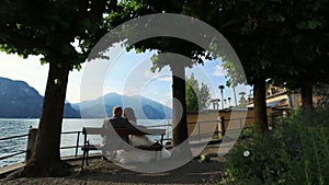 Wedding couple kiss on the bench at the lake Como, Italy