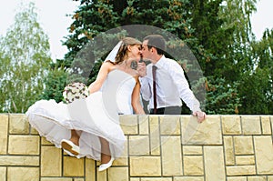 Wedding couple kiss and dangle feet. Tenderness loving