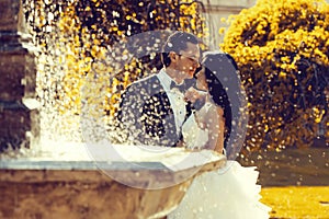 Wedding couple kiss near fountain water