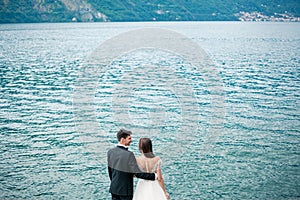 Wedding couple kissing on the background of a lake and mountains