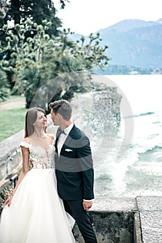 Wedding couple kissing on the background of a lake and mountains