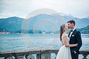 Wedding couple kissing on the background of a lake and mountains