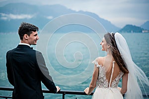 A wedding couple kissing on the background of a lake and mountains