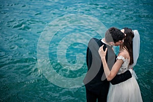 A wedding couple kissing on the background of a lake and mountains