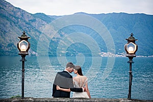 Wedding couple kissing on the background of the lake and the mountains