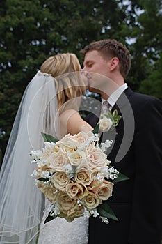 Wedding Couple Kissing with Bouquet