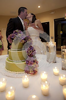 Wedding couple kissing by cake