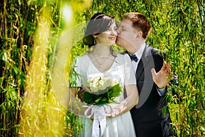 Wedding couple kissing in the green park