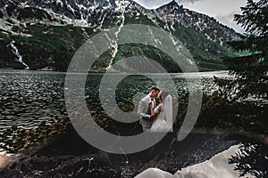 Wedding couple kissing near the lake in Tatra mountains in Poland. Morskie Oko. Beautiful summer day