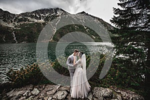 Wedding couple kissing near the lake in Tatra mountains in Poland. Morskie Oko. Beautiful summer day