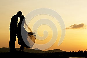 Wedding couple kissing with sunset