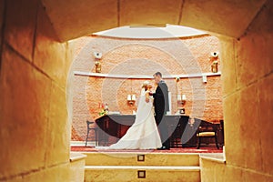 A wedding couple look at each other standing in the entrance