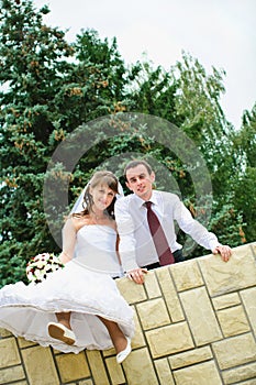 Wedding couple looking and dangle feet. Tenderness loving