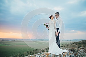 Wedding couple looking in mountain hill on sunset