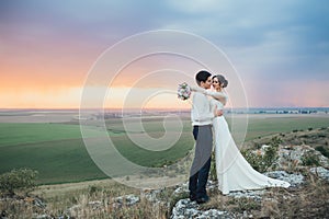 Wedding couple looking in mountain hill on sunset