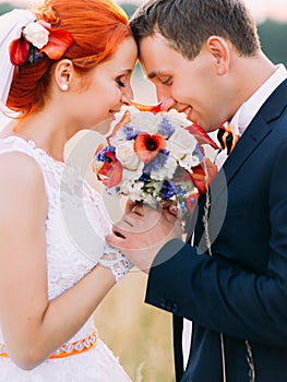 Wedding couple in love enjoy a moment of happiness and lovingly look at each other on wheat field