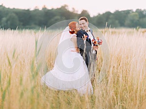 Wedding couple in love enjoy a moment of happiness and lovingly look at each other on wheat field