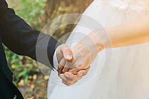 Wedding couple in love. Groom is holding the bride`s hand. Love story